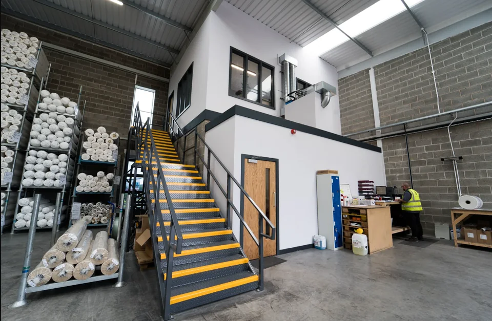 Warehouse interior with storage areas and a mezzanine office